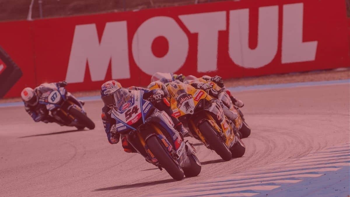 Carrera de motos patrocinada por Motul en la que aparecen varios pilotos en una curva.